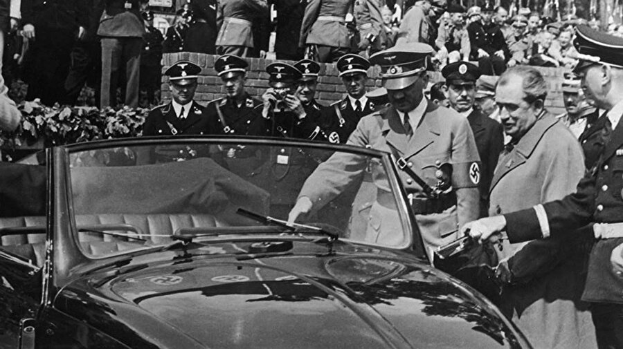 Beetle fabrika açılış konuşmasının ardından Adolf Hitler. Ferdinand Porsche ile birlikte kendisine hediye edilen Cabriolet modeli inceliyor.