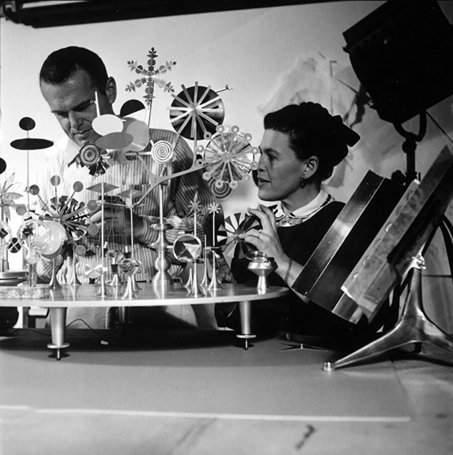 Eames çifti geri dönüşüm projesi olan bir rüzgargülü, bir güneş paneli ya da adı üstünde hiçbir şey yapmayan bir makina olarak görülen “Solar Do-Nothing Machine” üzerinde çalışıyor. 