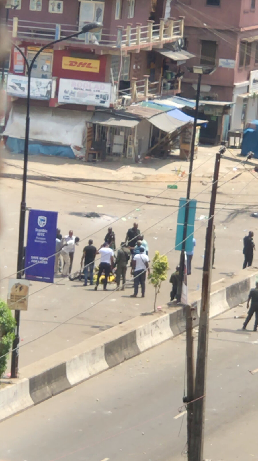 Edinilen görüntüye göre yerde uzanan bir adamın başında silahlı adamlar bulunuyor, Lagos, 21 Ekim 2020