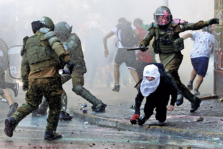 Yerli halka yaptıklarının aynısını, 1973’te darbe ile başa gelen diktatör Pinochet kendi halkına uygulamıştı. Binlerce insan ayaklarına beton dökülerek denize atıldı. Binlercesi kaybedildi. İşkence merkezleri insanlık tarihine geçecek nitelikteydi. Yüzyıllar önce ülkeye ilk ayak bastıklarında İspanyol ‘kâşiflerin’ yerlilere yaptıkları, daha modern tekniklerle bugün barbarların öz torunlarına uygulanıyor.