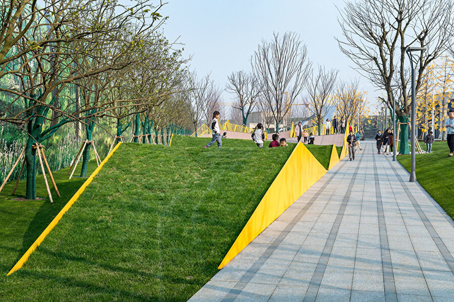 Oyun alanlarında kullanılan çim, parkı bulunduğu ortamla bütünleştiriliyor.