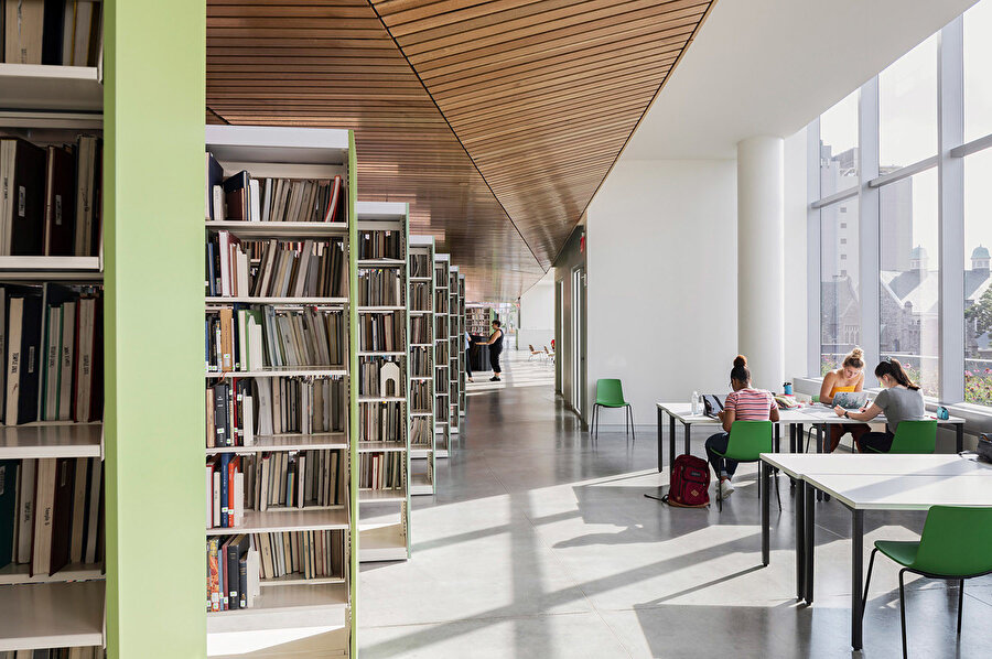 50'den fazla sıra soluk yeşil kitaplık, dikdörtgen üst katın ortasına yayılıyor ve yaklaşık 200.000 kitap barındırıyor.