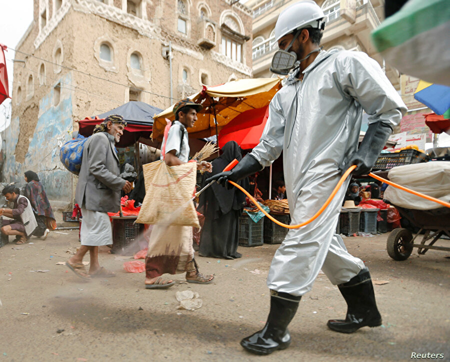 Yemen'de bir pazar yerini dezenfekte eden görevli.