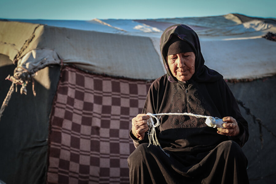 İğne iplikle çadırlarını yamayan İdlibli kadınlar.