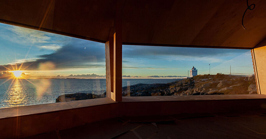 Büyük kabinin pencerelerinden görülen gün batımı ve Ryvarden Deniz Feneri.