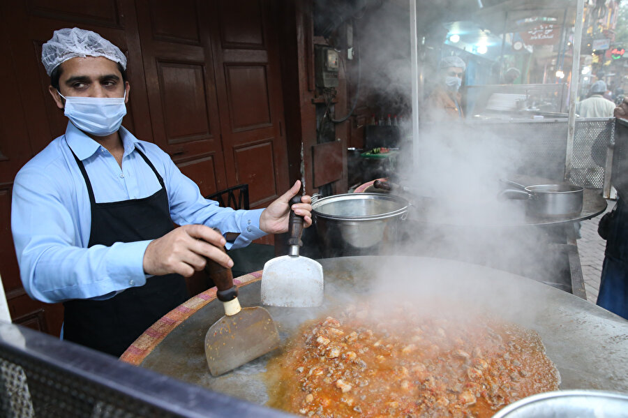 Renkli binaların önünde sıra sıra dizilen satıcılar, Lahor’un kendine has baharatlı yemeklerini turistlerin beğenisine sunuyor.