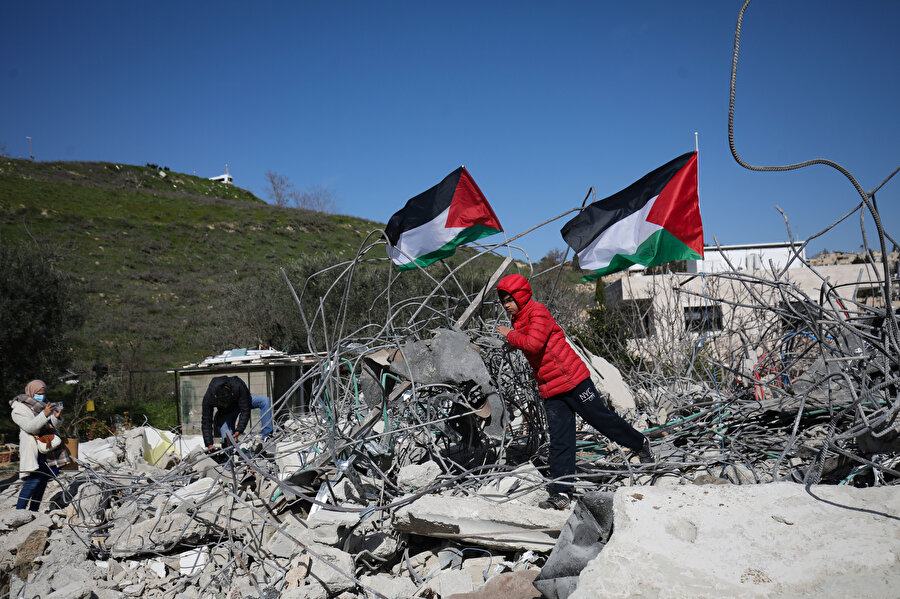Yıkılan binaların üzerinde dalgalanan Filistin bayrakları.