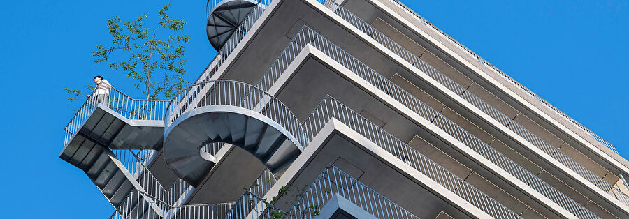 Birbirinden farklı tasarımlara sahip çelik merdivenler, aynı zamanda birer balkon görevi görüyor. 