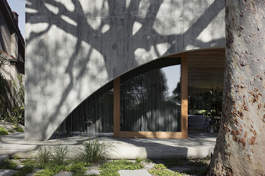 Mimarlar, dış cephe malzemesinin oluşturduğu sert izlenimlerin tersine evin, mevcut ağaçların gölgeleri ile keyifli bir tasarım olduğunu savunuyor.