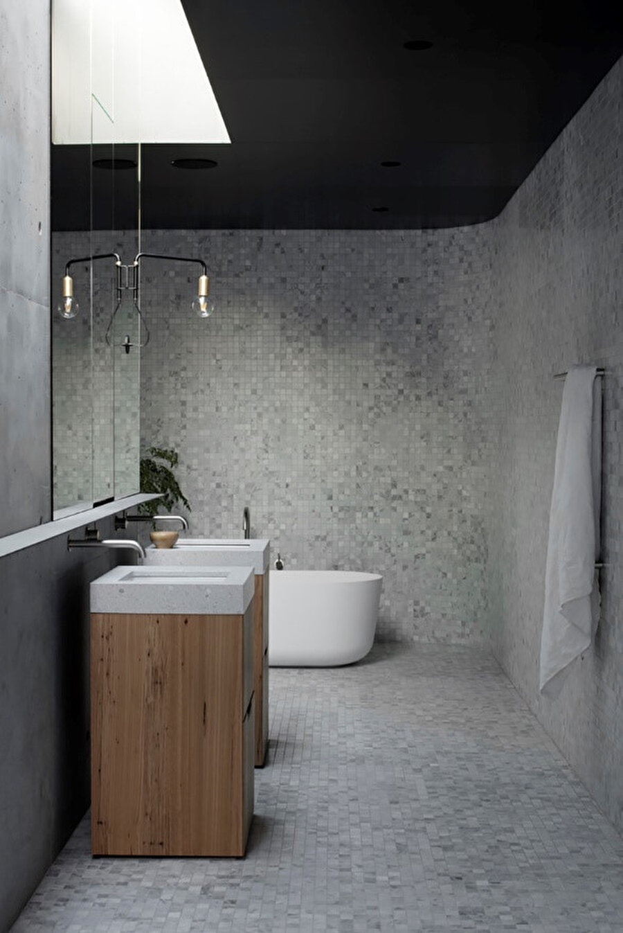 Tavanda, duvarda ve mobilyalarda kullanılan beton ve ahşap kombinasyonu ile tasarımda dil birliği sağlanıyor. (Ebeveyn banyosu.)