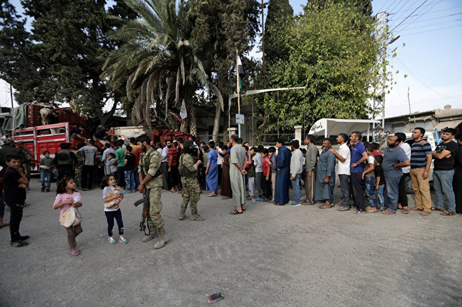 Tel Abyad'da ekmek kuyruğunda bekleyen Suriyeliler.