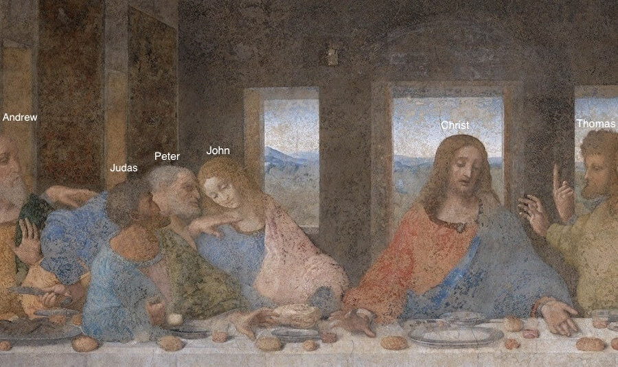 Yahuda ve İsa elini aynı kaseye uzatırken İsa ayrıca, şarap ve ekmeği de işaret etmektedir.