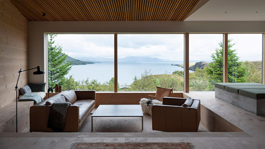 Evin yaşam alanındaki geniş pencereler, kullanıcılara panoramik bir göl manzarası sunuyor.