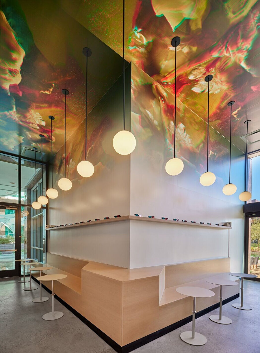 Kafenin minimalist tasarımı ile tavan resmi kontrast oluşturarak birbirini tamamlıyor.