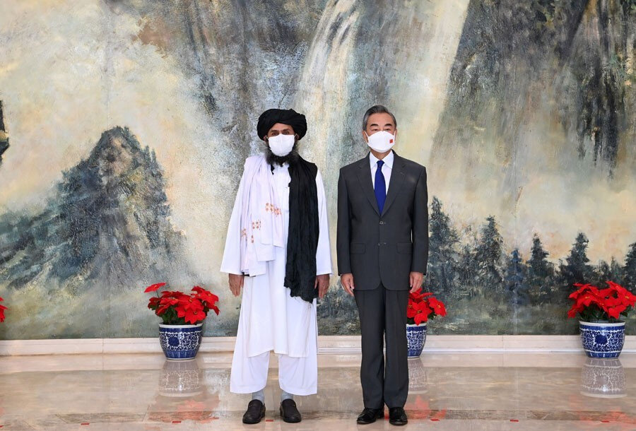 Taliban'ın Katar'daki Siyasi Bürosunun Başkanı Molla Abdul Gani Birader (solda) ve Çin Dışişleri Bakanı Vang Yi (sağda).