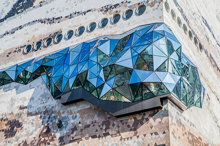 Cephedeki kristal açıklıklar, iç mekandaki faaliyetleri şehre gösteren vitrinler olarak da görev görüyor.