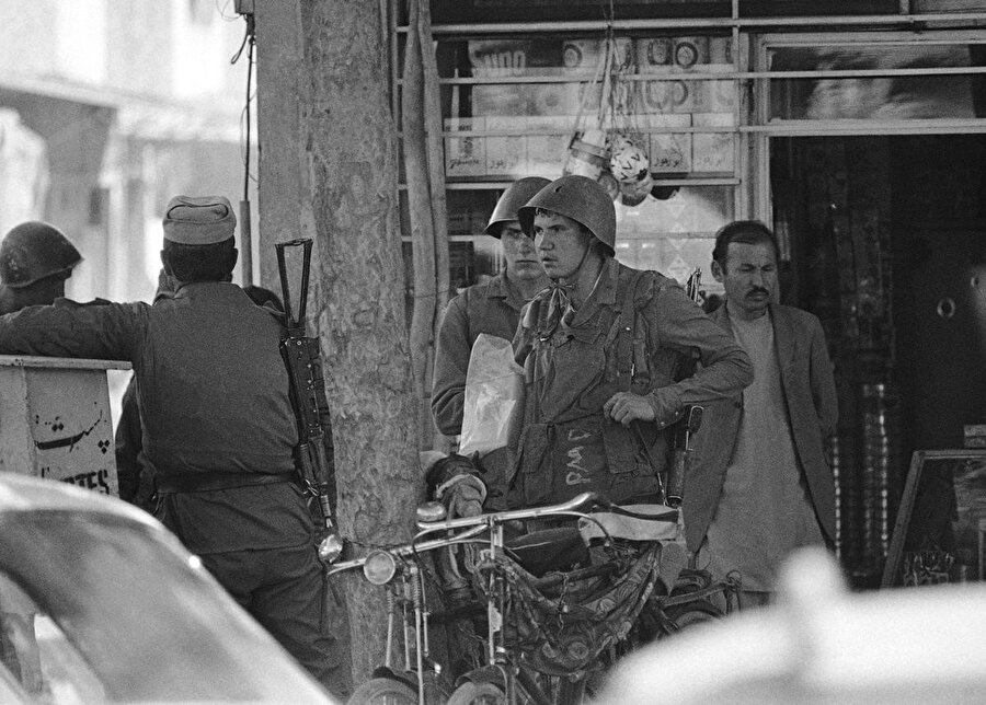 24 Nisan 1988'de Kabil şehir merkezinde Afganların işlettiği bir dükkândan çıkan iki Sovyet askeri.