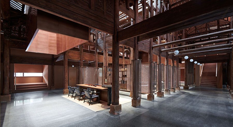 Bir Qing Hanedanı evinin restore edilmiş ahşap çerçevesi, ana salonun en önemli parçası olarak gösteriliyor.