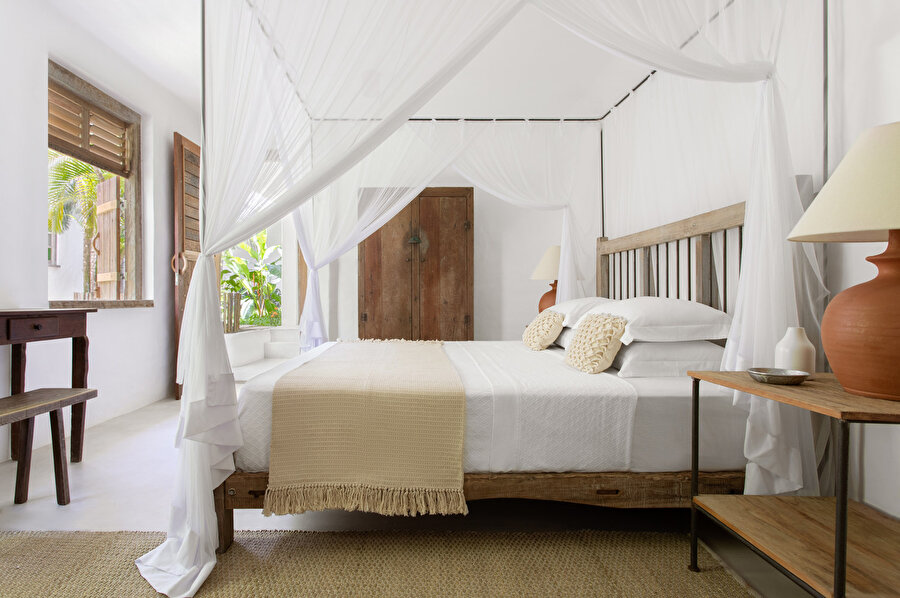 Yatak odası dekorasyon elemanları evin genelinde hakim olan beyaz renkle bir bütünlük oluşturuyor.
