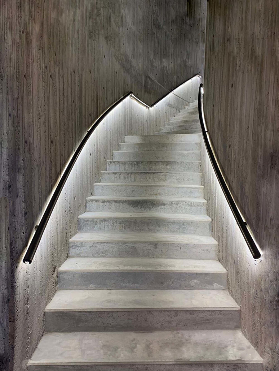 Merdiven, genel tasarımın formlarını takip ederek kıvrımlı şekilde yükseliyor.