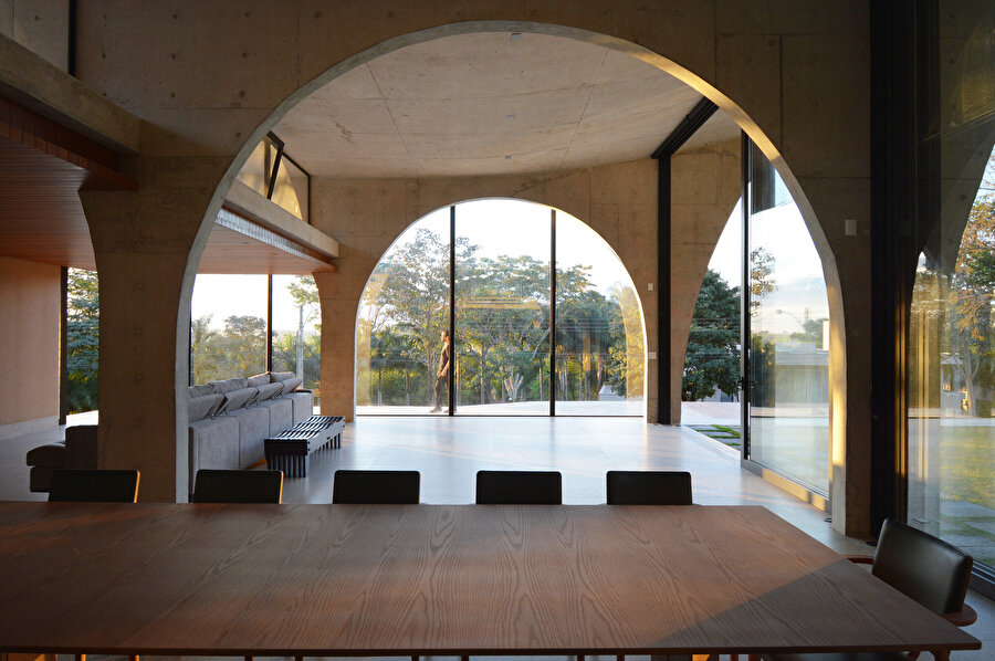 Evin geniş cam yüzeyleri kullanıcılara doğayla iç içe bir atmosfer sunuyor.