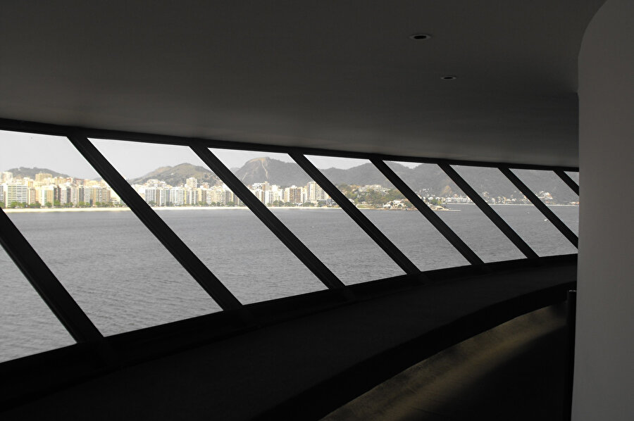 Eğimli pencereler, yapıyı sararak 360° manzara sunuyor.