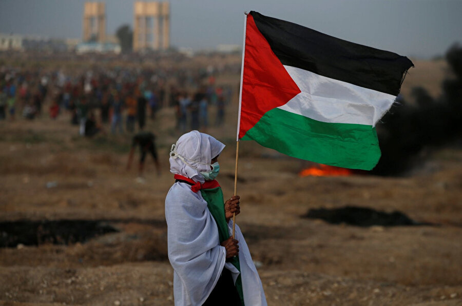 Filistin bayrağı tutan bir kadın.