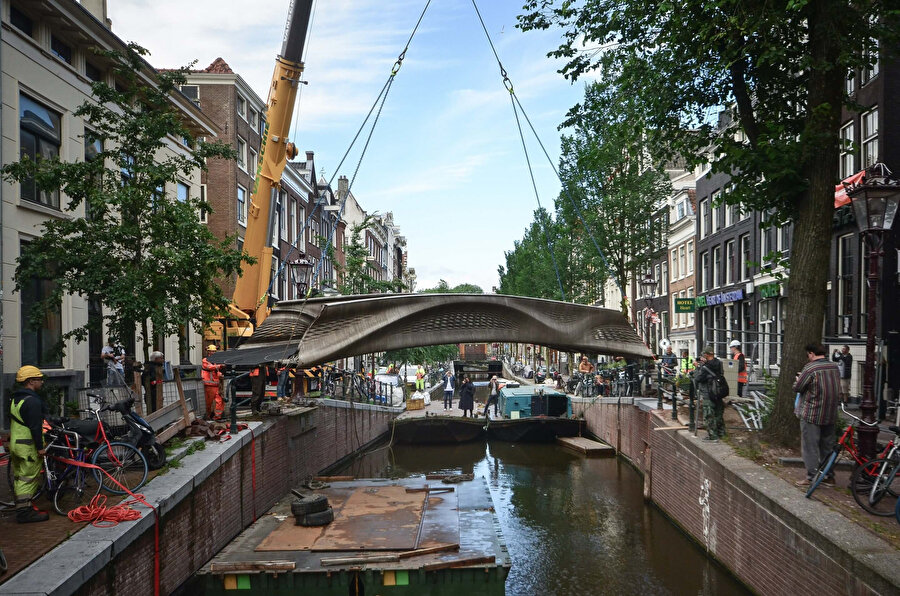 6 tonluk köprü, mavna ile Oudezijds Achterburgwal'a taşınıyor ve vinçle yerine oturtuluyor.