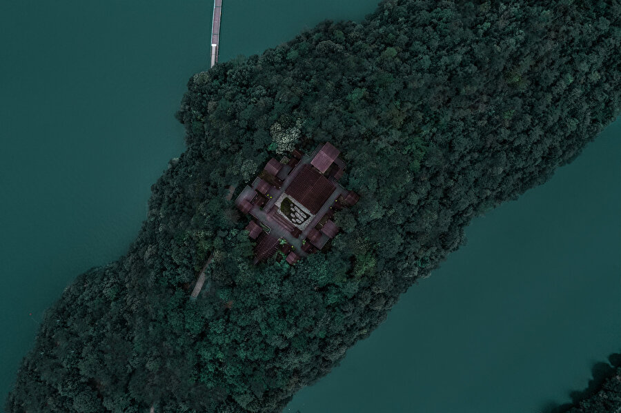 Adanın üstünde konumlanan tasarım, orman içerisinde yüzen bir ahşap kümeyi andırıyor.