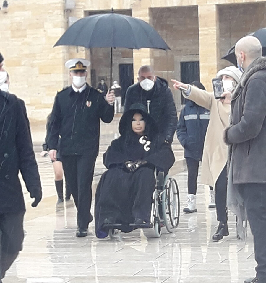 Görüntülerde bir subayın Ersoy'a şemsiye tuttuğu görülüyor