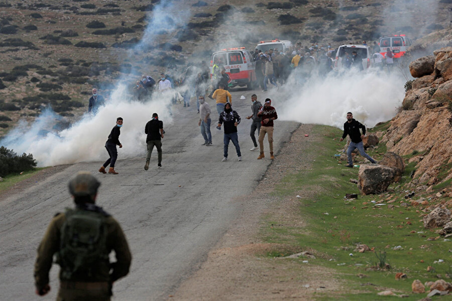 Ürdün Vadisi'ndeki Yahudi yerleşimlerini protesto eden Filistinli göstericiler, çatışmalar sırasında göz yaşartıcı gazın ortasında İsrail güçlerine taş atıyor, 24 Kasım 2020.