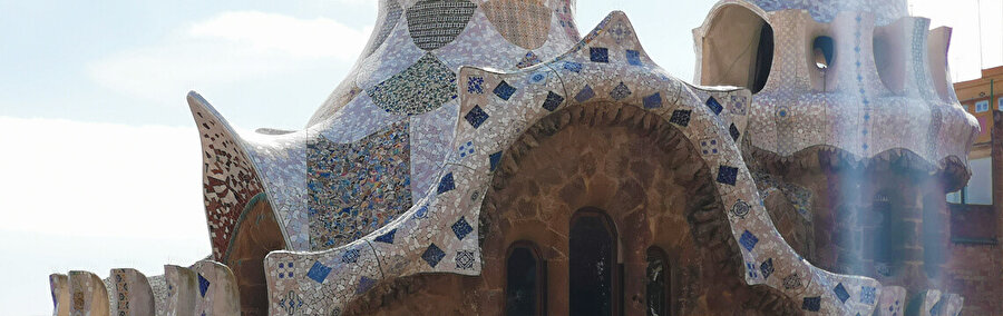  Giriş köşklerinin çatıları, kiremit parçalarından oluşan bir mozaik olan “trencadís” ile kaplanmış geleneksel Katalan kil kiremitleriyle inşa ediliyor.