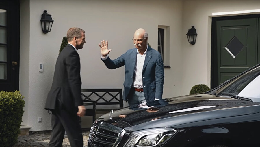 Kapıda bekleyen Mercedes S serisinden bir araca binen emekli CEO, yavaş yavaş binadan uzaklaşırken fon müziğindeki hüznün tonu da yükseliyor.