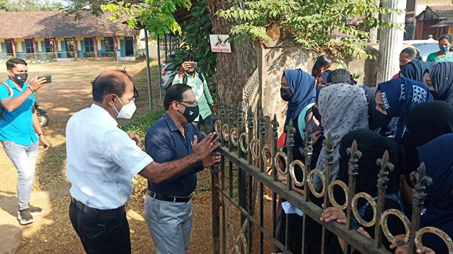 Karnataka'da bir üniversite kapısının önünde başörtülü öğrencileri gösteren bir videodan.