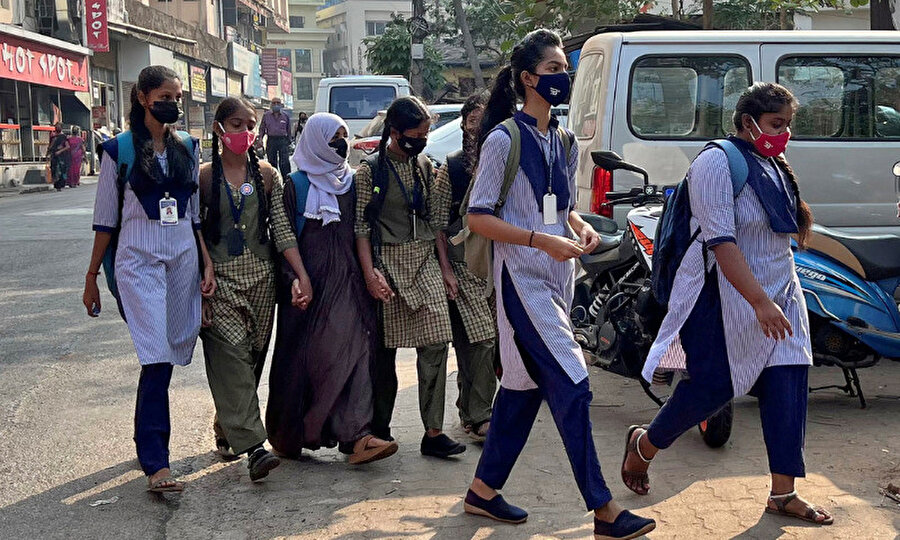 Udepi kasabasındaki başörtüsü takan bir kız öğrenci, son başörtüsü yasağının ardından kız okulundaki derslerine katılmak için sınıf arkadaşlarının ellerini tutuyor, 16 Şubat 2022.
