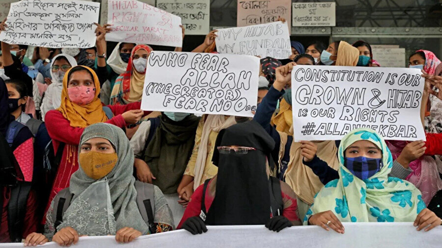 Hindistan'daki başörtüsü yasağını protesto eden Müslüman kadınlar, "Anayasa tacımız, tesettür hakkımız" yazılı pankart taşıyor, 9 Şubat 2022.