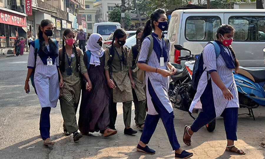 Udepi kasabasındaki başörtüsü takan bir kız öğrenci, son başörtüsü yasağının ardından okula giderken sınıf arkadaşlarının ellerini tutuyor, 16 Şubat 2022.