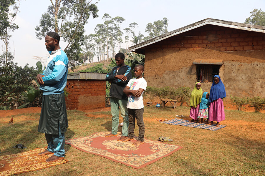 Animist inancına sahipken Müslümanlığı benimseyen Muhammed, ailesiyle birlikte namaz kılıyor.