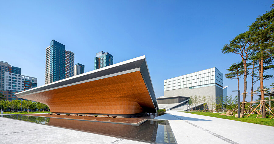 Binanın girişine yaklaşan ziyaretçileri yönlendirebilmek için peyzaj, sanat merkezi ile paralel olarak tasarlanıyor.