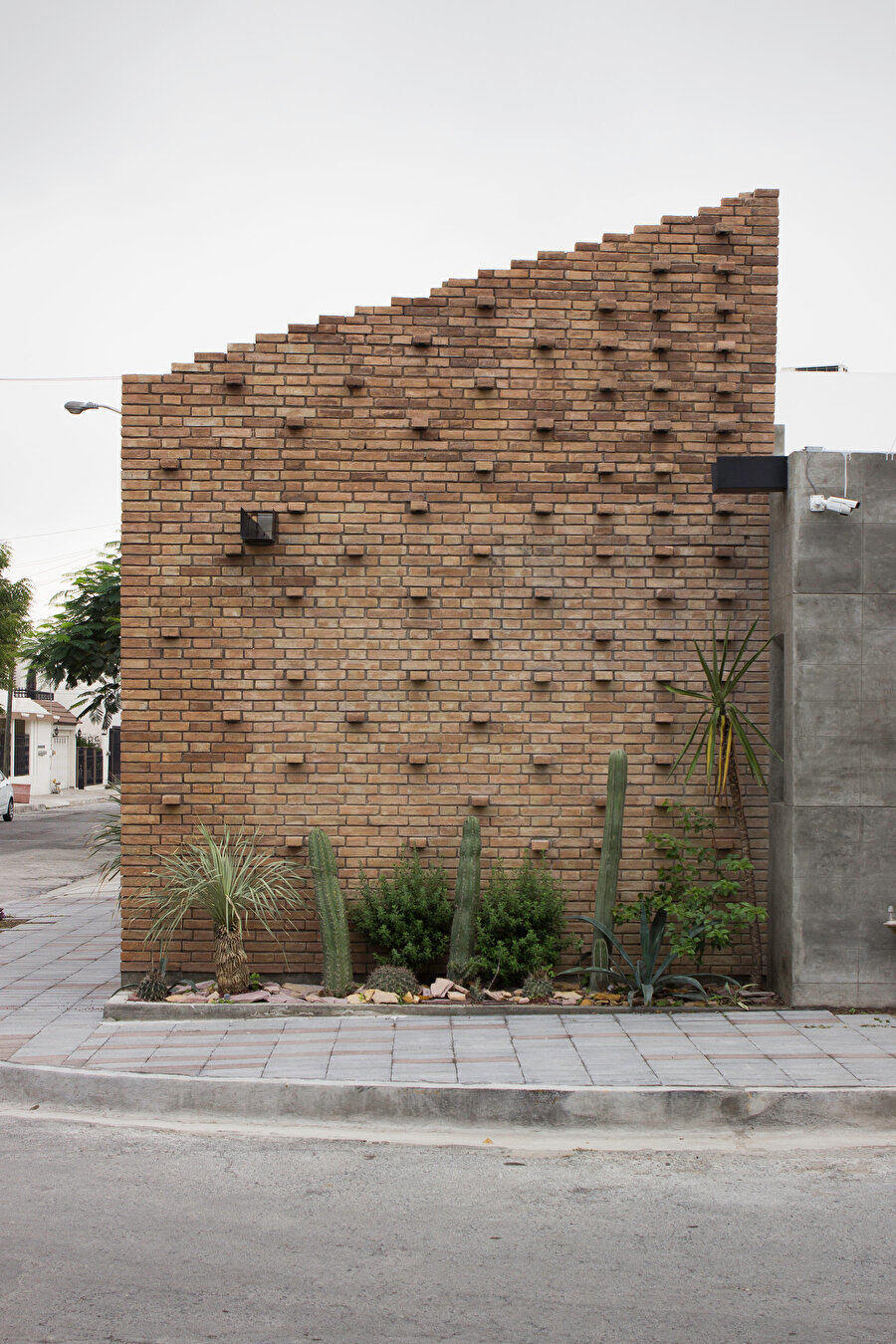 Tuğla duvar ve kamusal kaldırım.