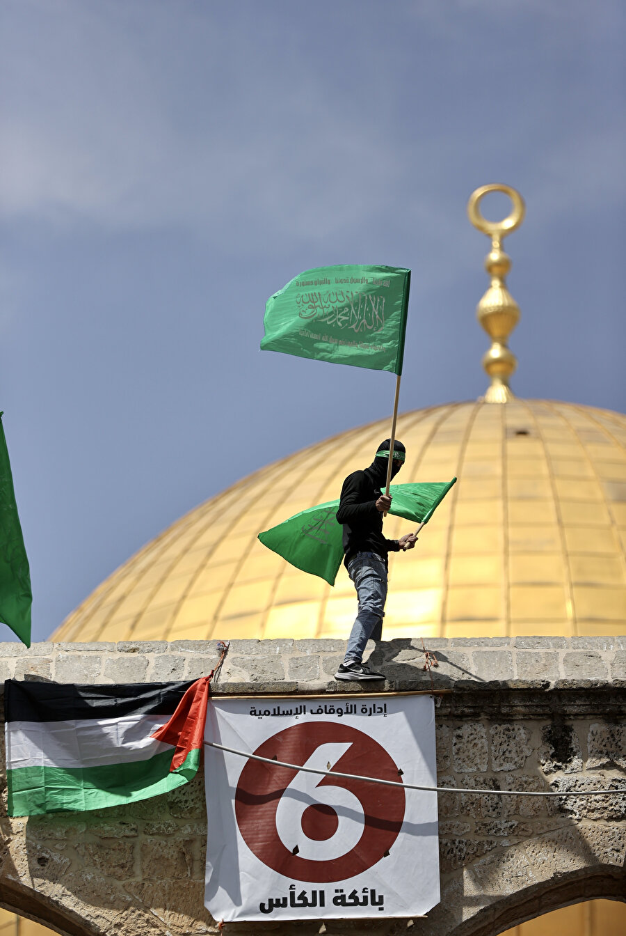 Bir Filistinli Kubbetu's Sahra Camisi'nin üzerine çıkarak Filistin bayrağı astı.