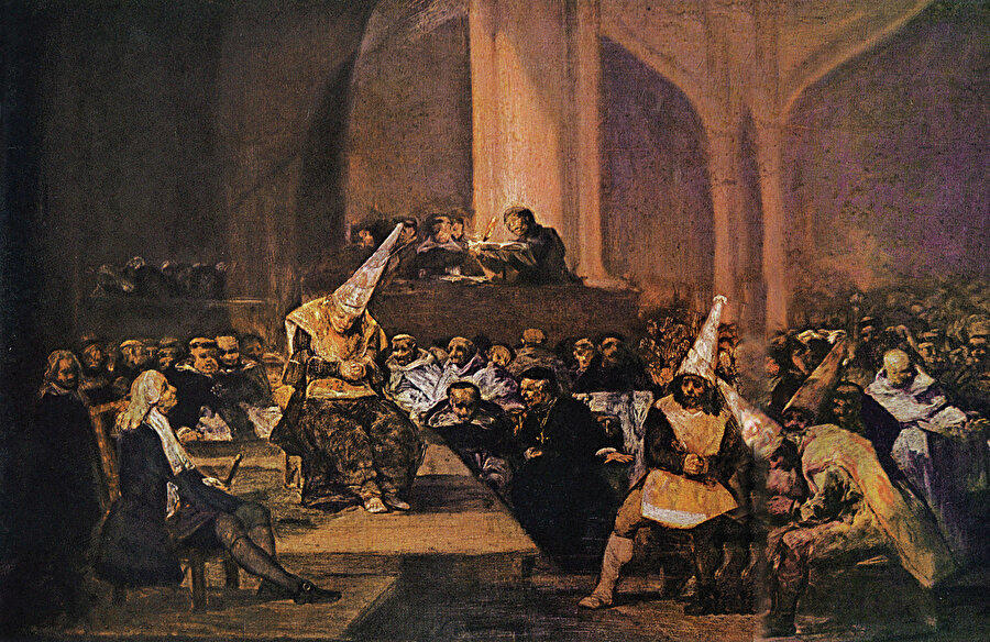 » Sanatçı gözüyle İspanya’nın öteki yüzü: Zincire bağlanmış ve konik şapka giydirilmiş sapkınların İspanyol Engizisyonu tarafından kilisede yargılanış sahnesi. Tablo, İspanyol ressam Francisco Goya’nın 19. yüzyıl İspanya’sının karanlık yüzünü cesurca gösteren eserler serisine ait.