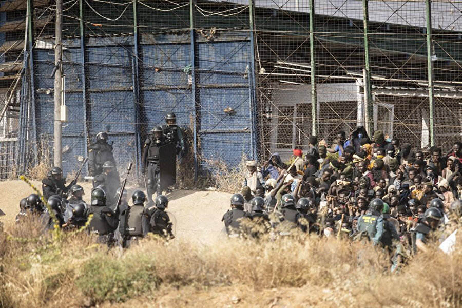 Göçmenler, İspanya'nın Melilla yerleşim bölgesini Fas'tan ayıran çitleri geçmeye çalışırken çevik kuvvet polisleri bölgeyi kordon altına aldı.