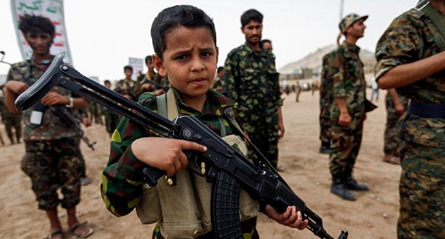 Elinde silahla poz veren bir 'çocuk asker'