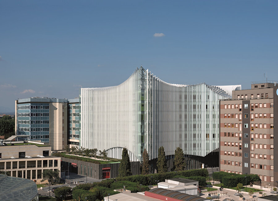 San Raffaele Hastanesi’nin çevresiyle olan ilişkisi; mevcut binalar 1970'ler ve 1980'lerden kalma olduğu için mimarileri bakımından büyük farklılıklar gösteriyor.