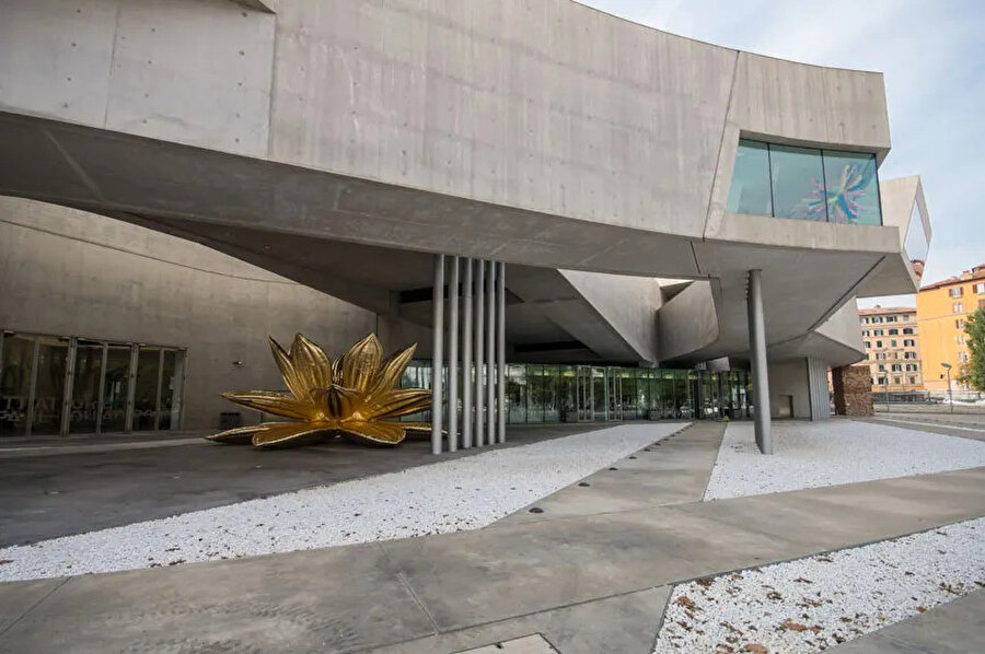 Choi Jeong-Hwa tarafından tasarlanan Golden Lotus enstalasyonu. Akdeniz'deki kurtarma operasyonları sırasında kullanılan acil durum termal battaniyeleri ile yapılan bu hareketli dev çiçek, MAXXI’nin avlusunda ziyaretçileri karşılıyor.