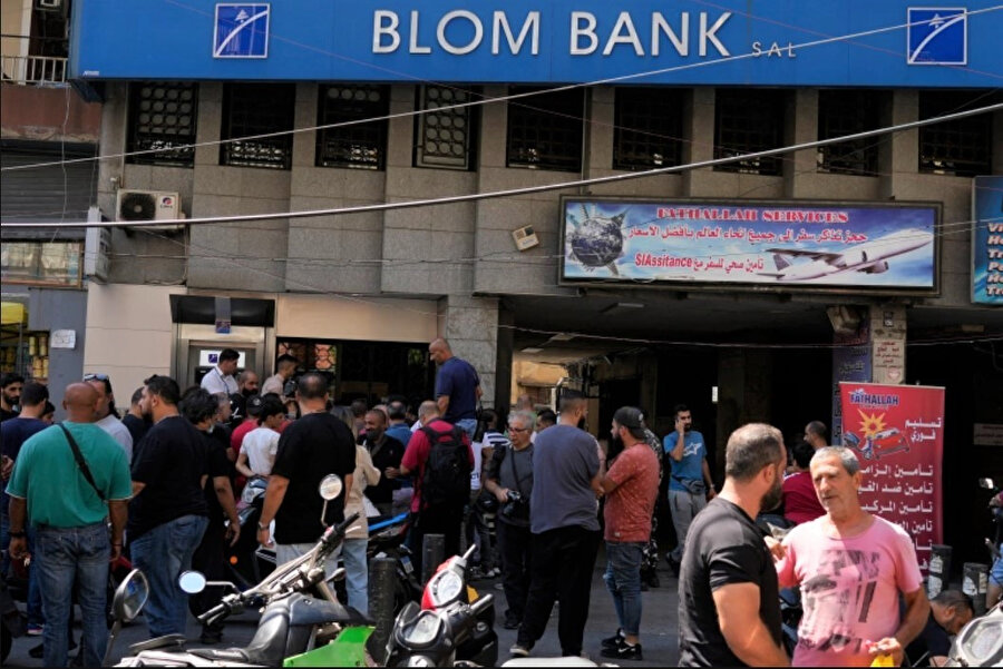Bankalarda parası bulunan müşteriler, krizden etkilenen Lübnan'ın farklı bölgelerinde en az sekiz bankaya girerek kapana kısılmış birikimlerine erişim talep etti.