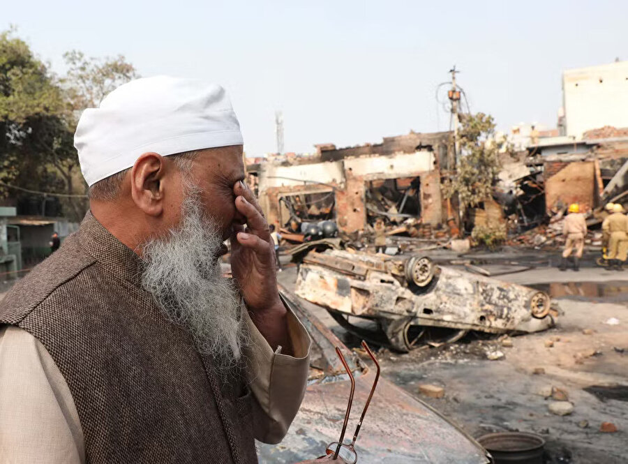 Müslüman bir adam, Hindu milliyetçileri tarafından yakılıp yıkılan pazar yerine bakıyor.