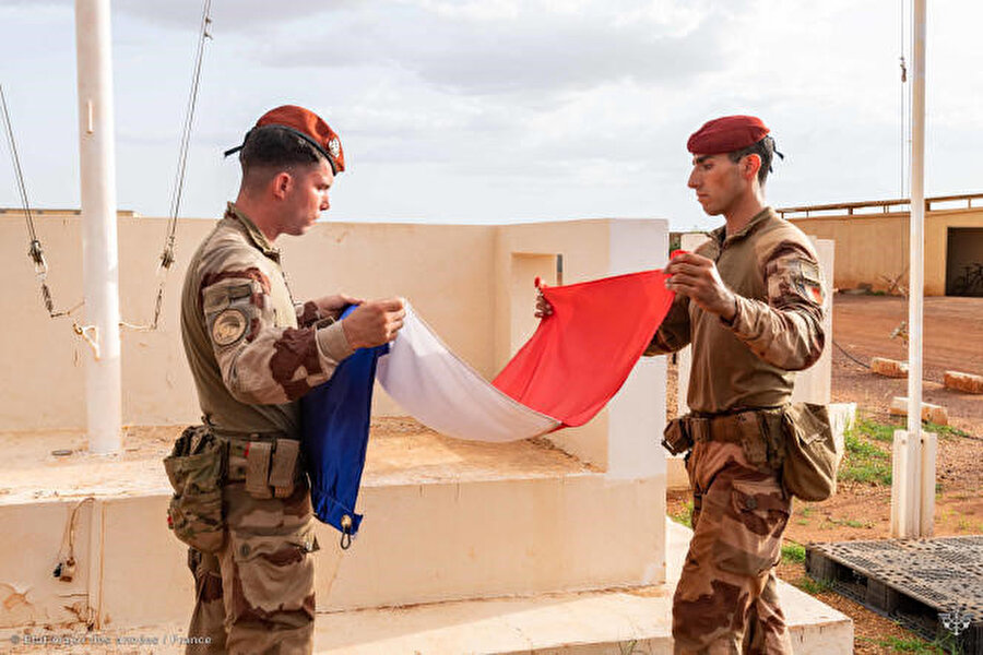 "Barkhane" askerî misyonundan Fransız askerler, ordunun geri çekilmesinin bir parçası olarak Mali'deki askerî tesiste bulunan Fransız bayrağını katlıyor, 11 Ağustos 2022.
