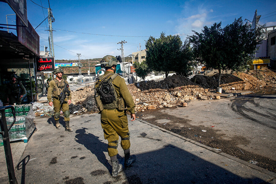 21 günlük kuşatma devam ederken Batı Şeria'nın Nablus yakınlarındaki Deir Sharaf'ın girişini engelleyen İsrail askerleri, 12 Ekim 2022.